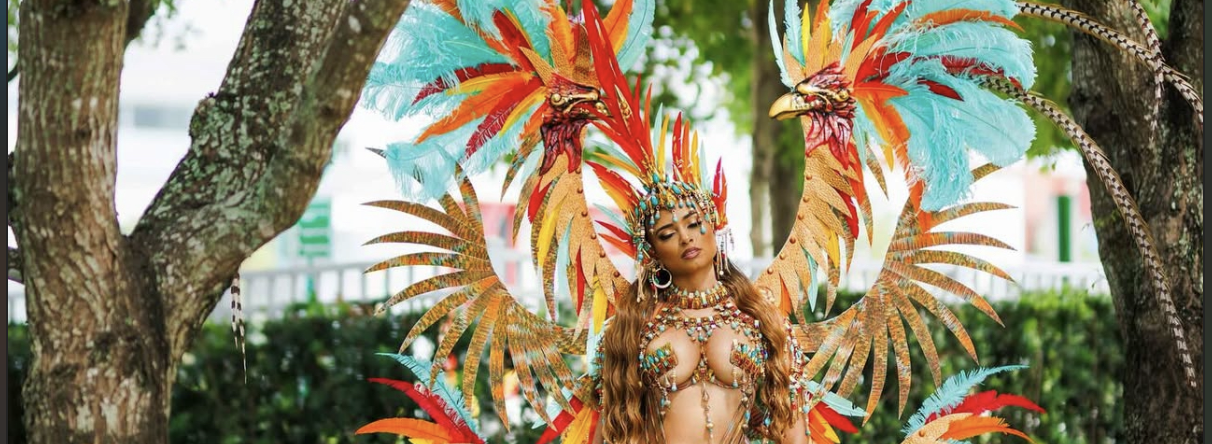 Carnival Glam Hub masquerader in a feathered Jamaica Carnival costume